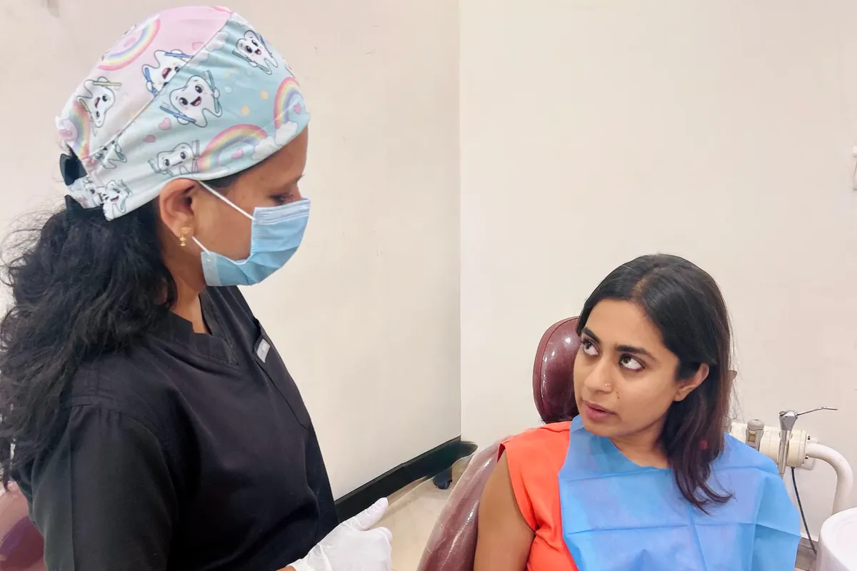 Dentist talking to a patient seated in the dental chair at Perfect Smile Dental Clinic